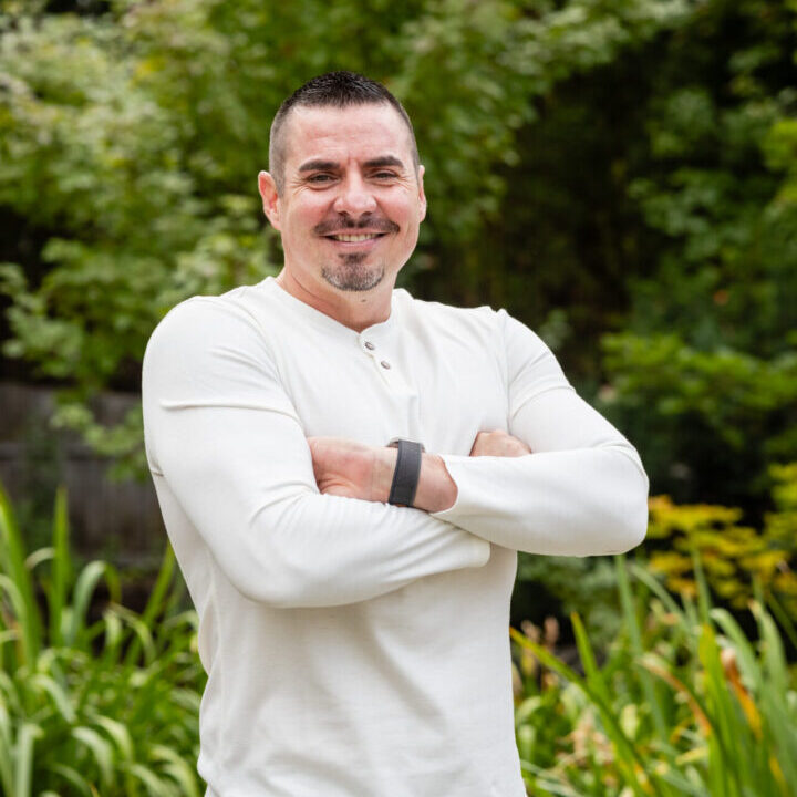 A man standing in front of some bushes